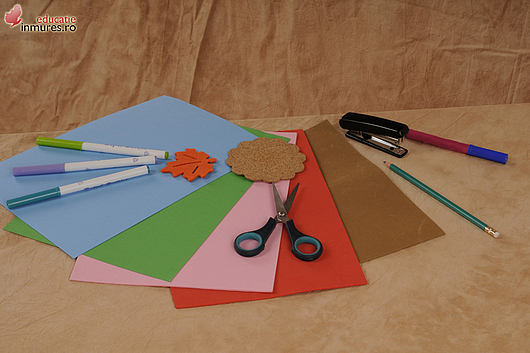 Materiale necesare: 1 coală de hârtie cu relief,1 frunză din material textil sau din carton,1 floare din plută sau din carton, lipici, foarfecă.